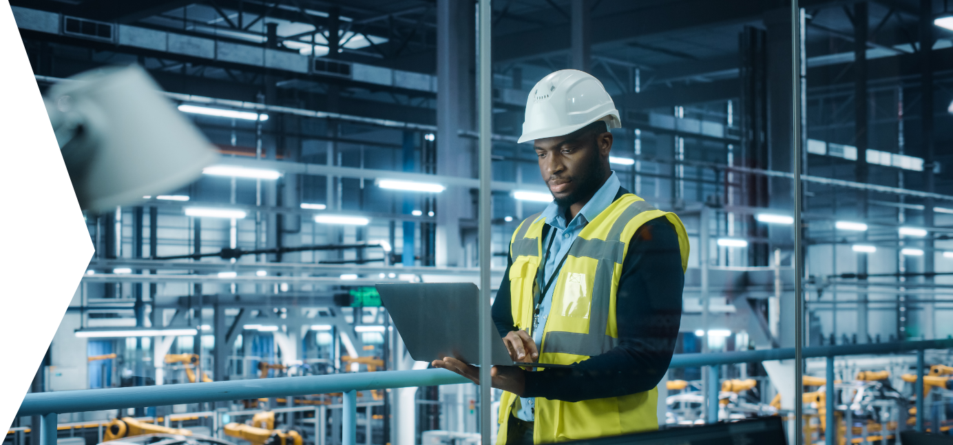 A man in a hardhat working on a laptop