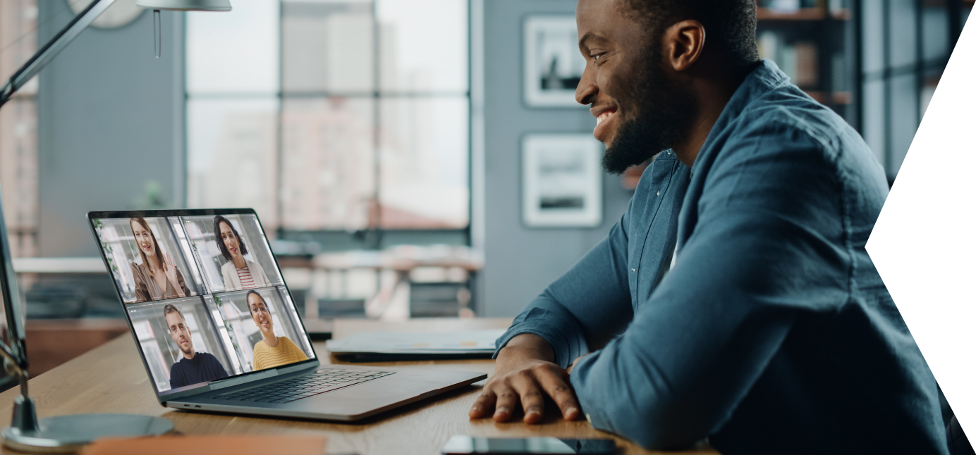 a smiling man using his laptop for a video call