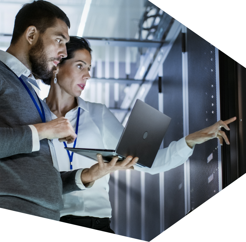 A man and a Woman investigating a server while holding a laptop