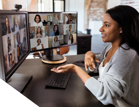 A woman on a video call, chatting with people on two monitors